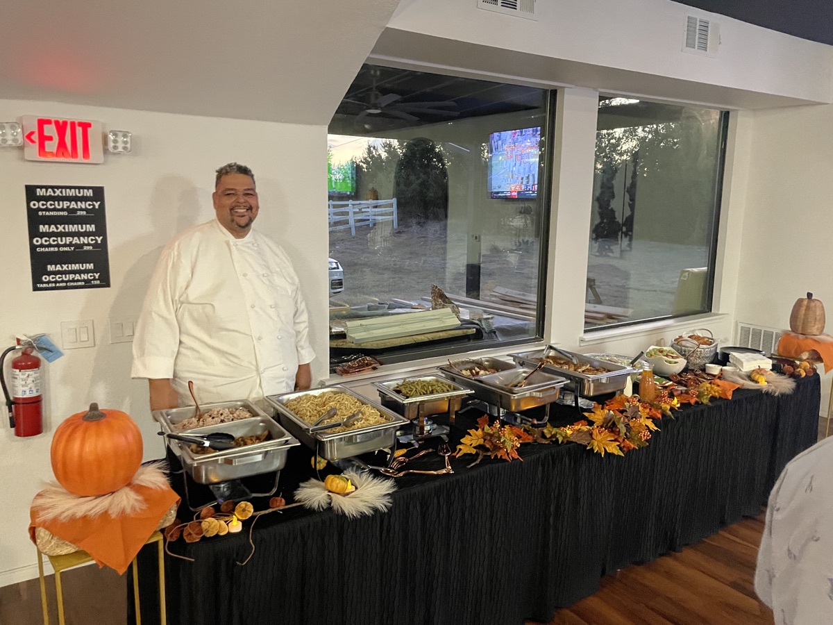 Chef beside a Thanksgiving-style buffet