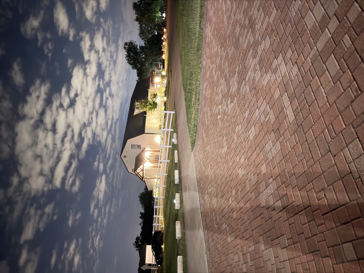 The venue at twilight with warm light and a cloud-streaked sky