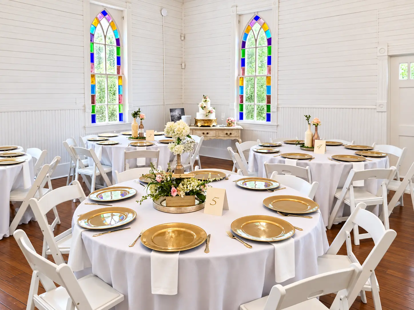 Wedding reception tables styled with gold details and florals